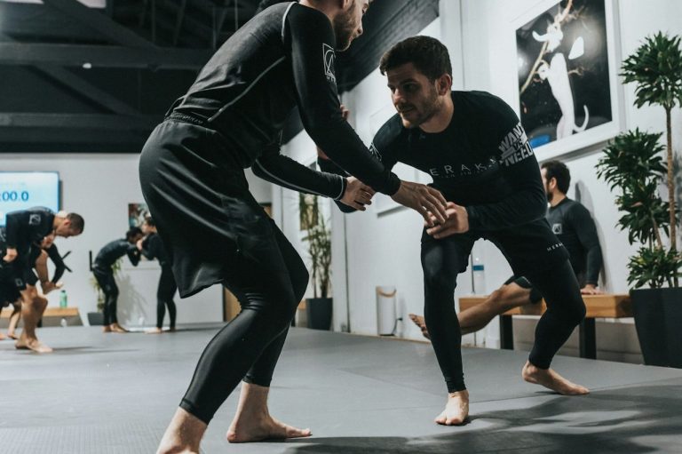 Zwei Sportler beim Grappling-Training in einer Halle.